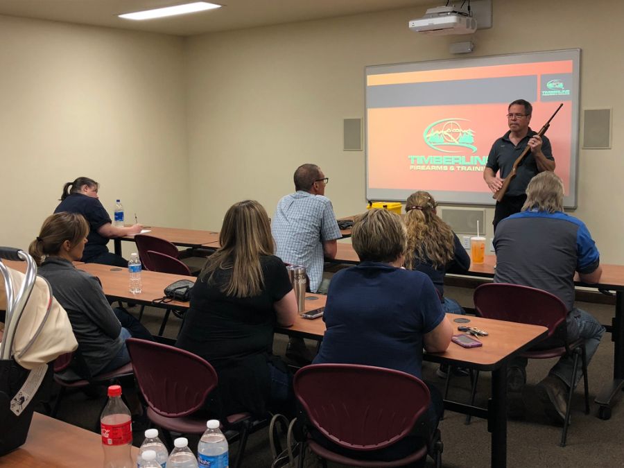 Instructor holding rifle during gun safety training class at Timberline Firearms